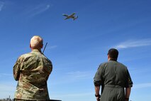 A photo of two Airmen watching a plane