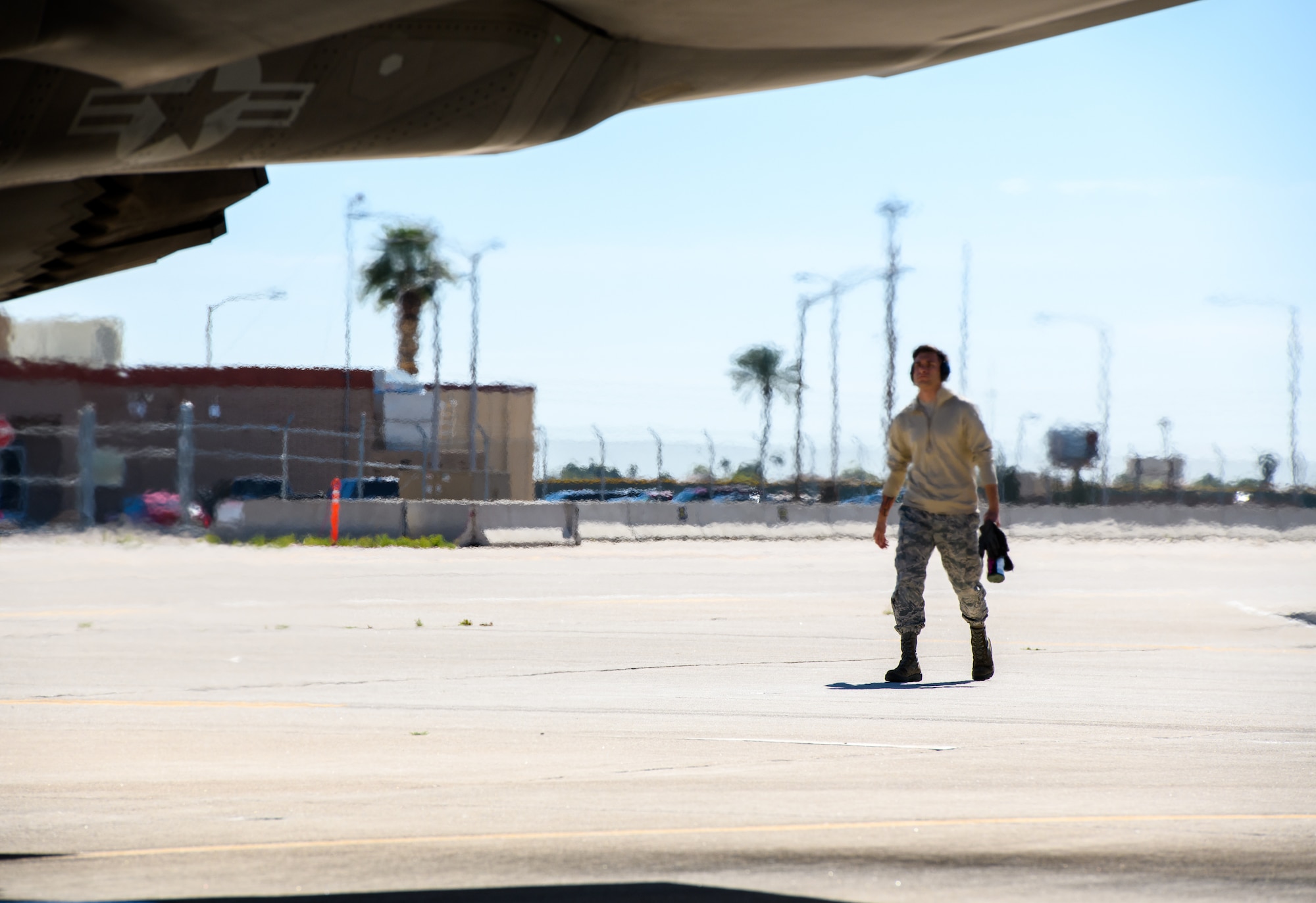 Senior Airman Benjamin Carlise, 56th Aircraft Maintenance Unit maintainer, walks on the flightline March 23, 2020, at Luke Air Force Base, Ariz.