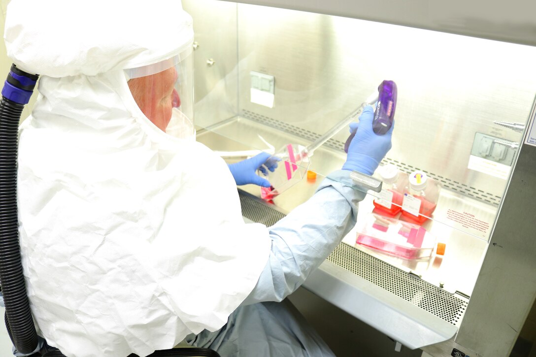 Researcher wearing full antiviral protection works in a laboratory.