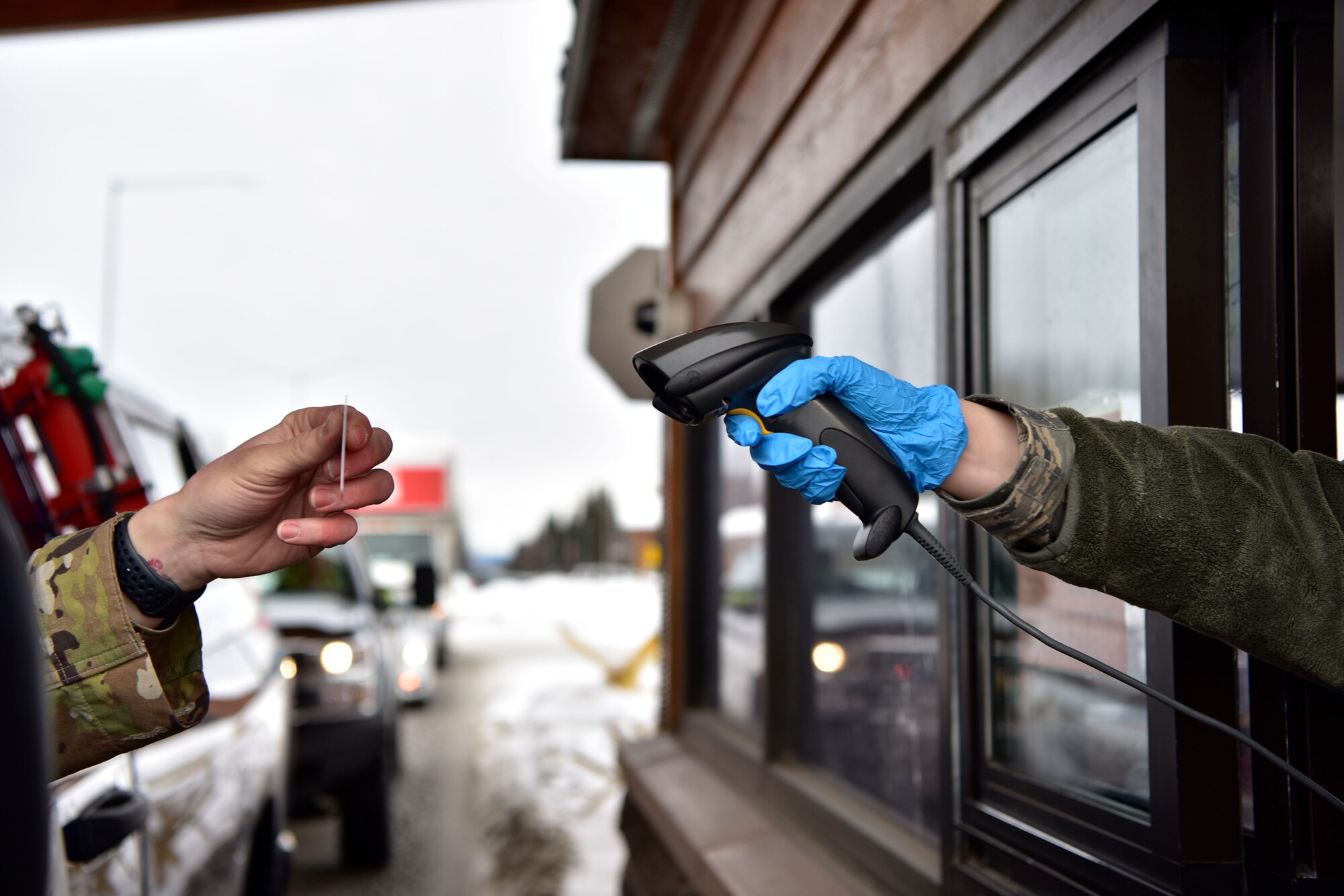 A 354th Security Forces Squadron Airman scans a common access card on Eielson Air Force Base, Alaska, March 20, 2020. Installation personnel and visitors must present their I.D. to defenders at the main gate for verification. The change is one of many precautionary measures implemented base-wide to help prevent the spread of COVID-19. (U.S. Air Force photo by Senior Airman Beaux Hebert)