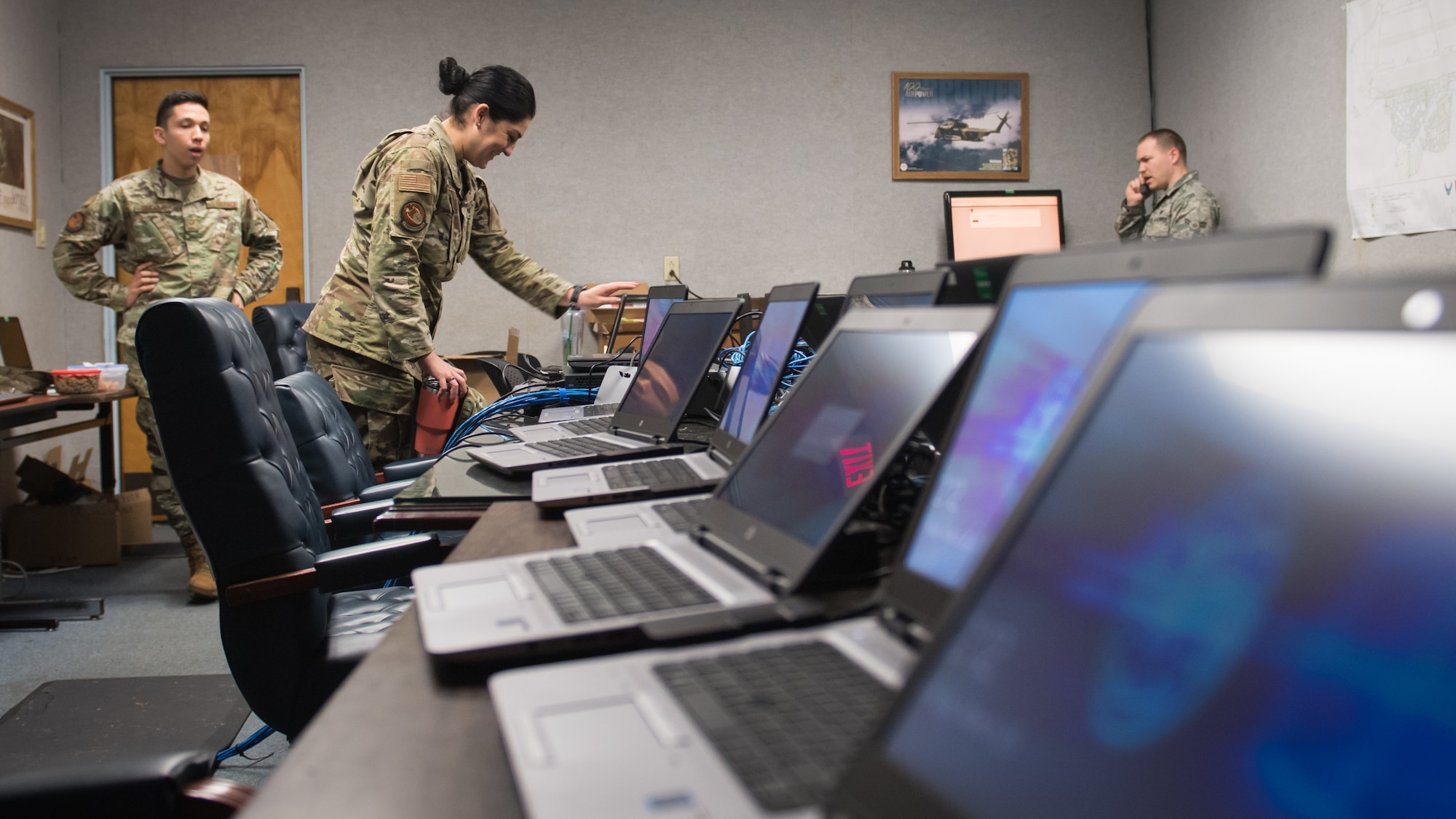Tech. Sgt. Jessica Oliver, 2nd Communications Squadron base equipment control office NCO-in-charge, looks over an inventory of laptops ready for customer use at  Barksdale Air Force Base, La., March 20, 2020. To meet the surge of teleworking personnel, the 2nd CS expanded operations of "The Hub," a walk-in computer clinic, by repurposing a conference room as a laptop porting station. (U.S. Air Force photo by Tech. Sgt. Daniel Martinez)