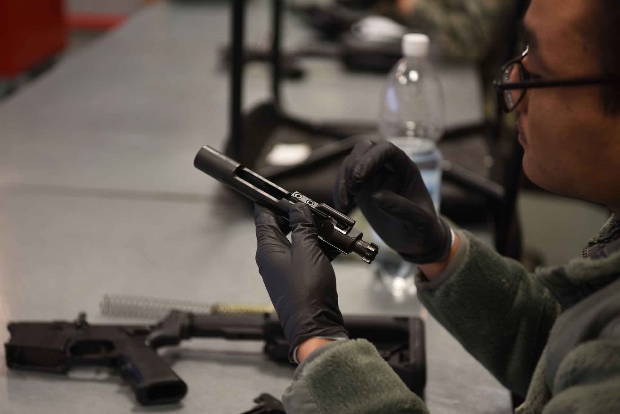 U.S. Air Force Senior Airman Roberto Umipeg, 86th Logistics Readiness Squadron fuel distributor operator, disassembles a bolt carrier of an M4 carbine assault rifle during a Combat Arms Training and Maintenance course.