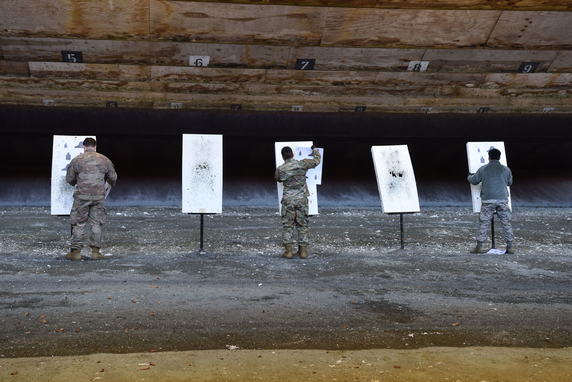 U.S. Airmen set-up paper targets on a shooting range during a Combat Arms Training and Maintenance course.