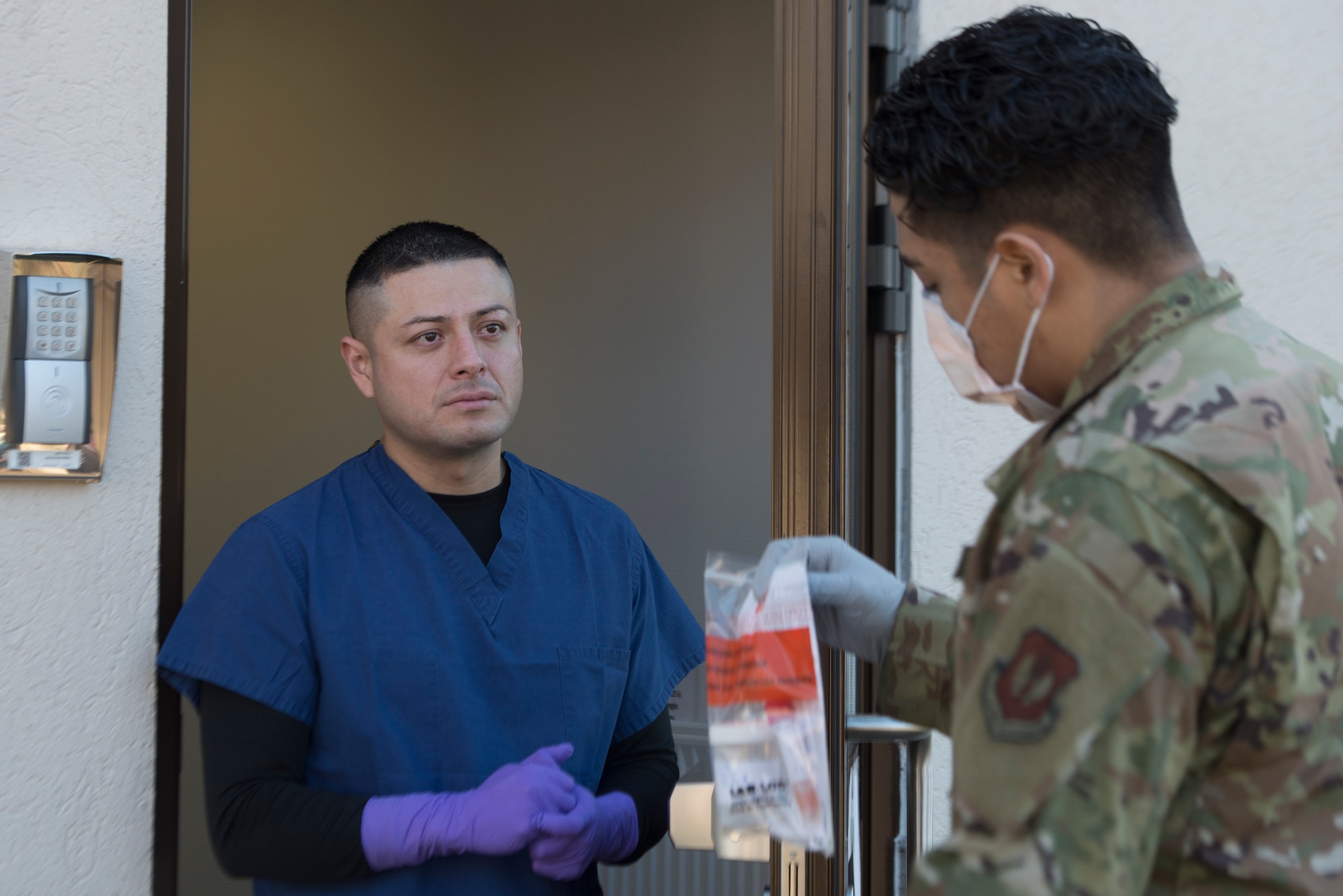 An Airman receives medical materials from a colleague.