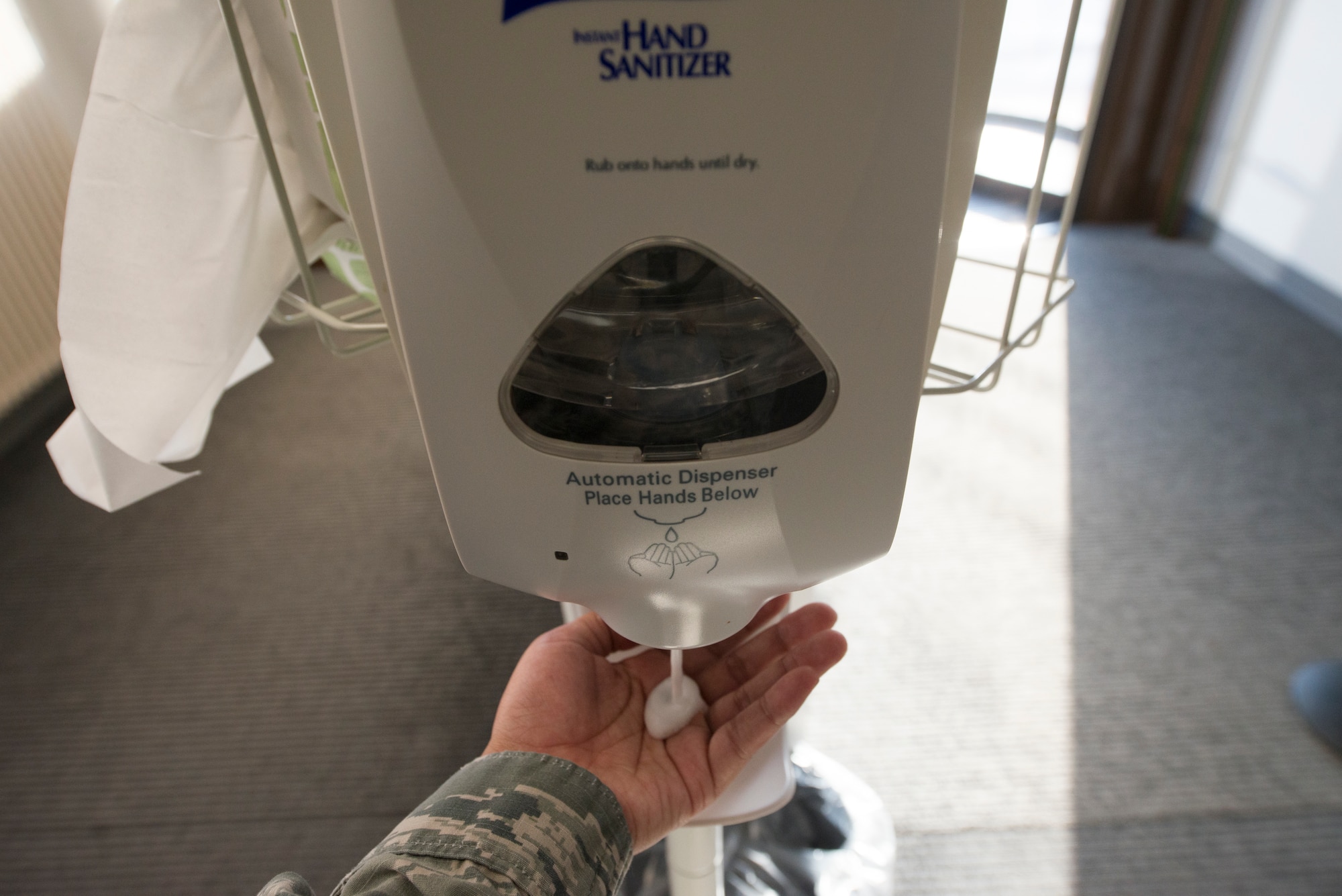 A picture of an Airman receiving hand sanitizer