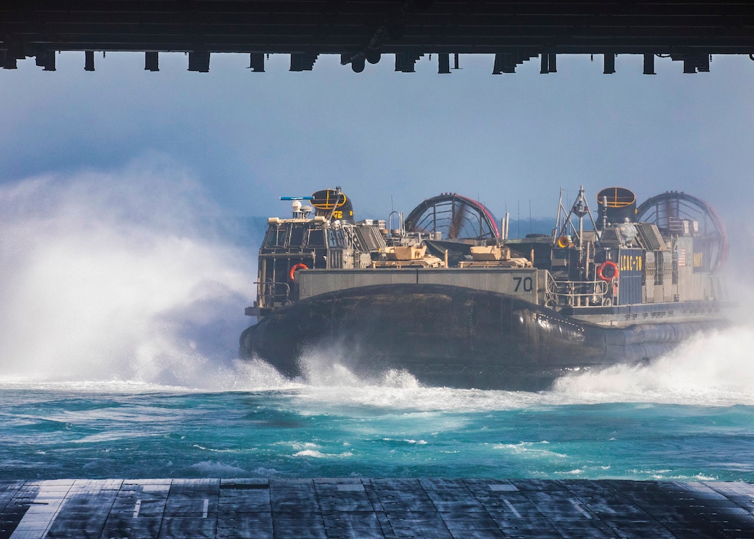 Landing Craft, Air Cushion 70, attached to Assault Craft Unit 4, departs from the well deck of the amphibious assault ship USS Bataan (LHD 5), March 19, 2020. Bataan is the flagship for the Bataan Amphibious Ready Group and, with the embarked 26th Marine Expeditionary Unit, is deployed to the U.S. 5th Fleet area of operations in support of naval operations to ensure maritime stability and security in the Central Region, connecting the Mediterranean and the Pacific through the Western Indian Ocean and three strategic choke points. (U.S. Navy photo by Mass Communication Specialist 3rd Class Alan L. Robertson)