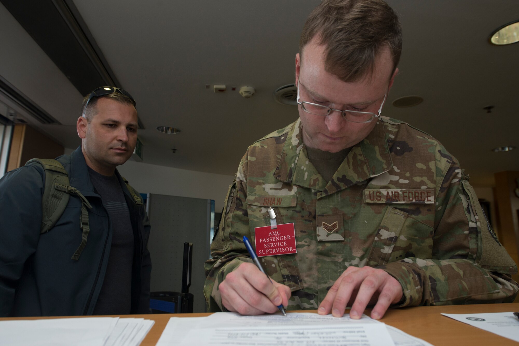 A picture of an Airman filing documents for a passenger.