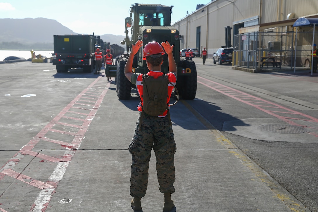A U.S. Marine guides a road grater during a Maritime Prepositioning Force exercise at U.S. Naval Base Guam, Feb. 28.
