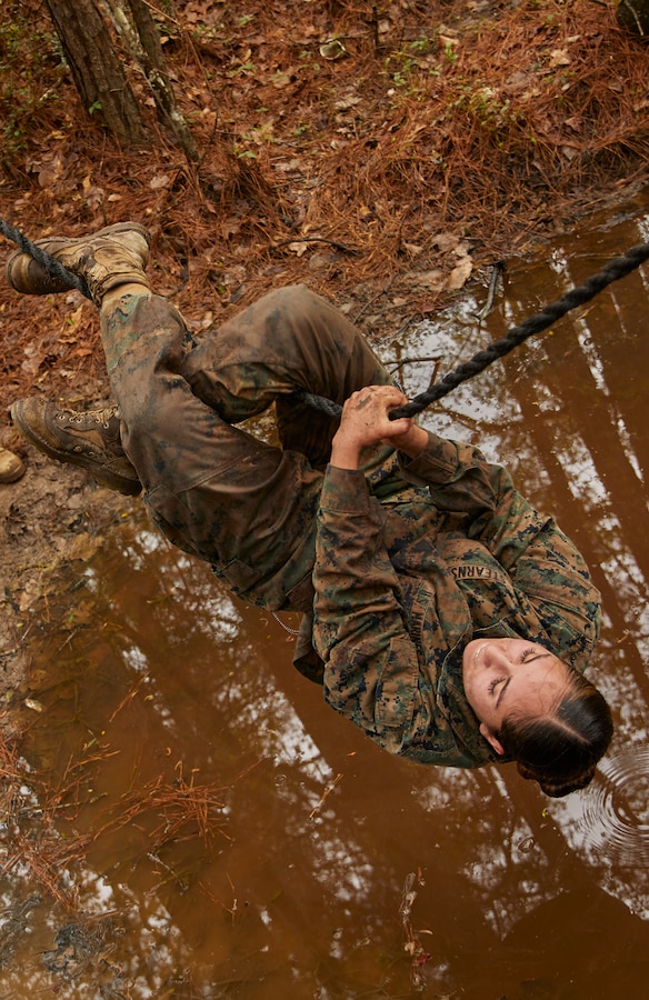 Cpl. Camila Stearns an administrative clerk with installation personnel administration center at Marine Corps Support Facility New Orleans, crosses a creek on a rope as part of a confidence course event during a field exercise at Camp Villere, Slidell, Louisiana, March 11, 2020. Marines participated in a confidence course which is designed to help build self-confidence and overcome fears both physically and mentally. (Marine Corps photo by Lance Cpl. Leslie Alcaraz)