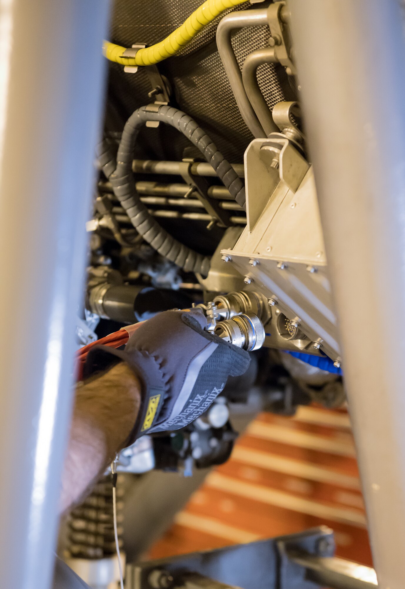 Evan Milligan, a journeyman wireman, connects cables to a F404 engine Jan. 10, 2020, in a sea level test cell at Arnold Air Force Base, Tenn. The engine is being prepared for use as a testbed by the Arnold Engineering Development Complex Technology, Analysis and Evaluation Branch. (U.S. Air Force photo by Jill Pickett)