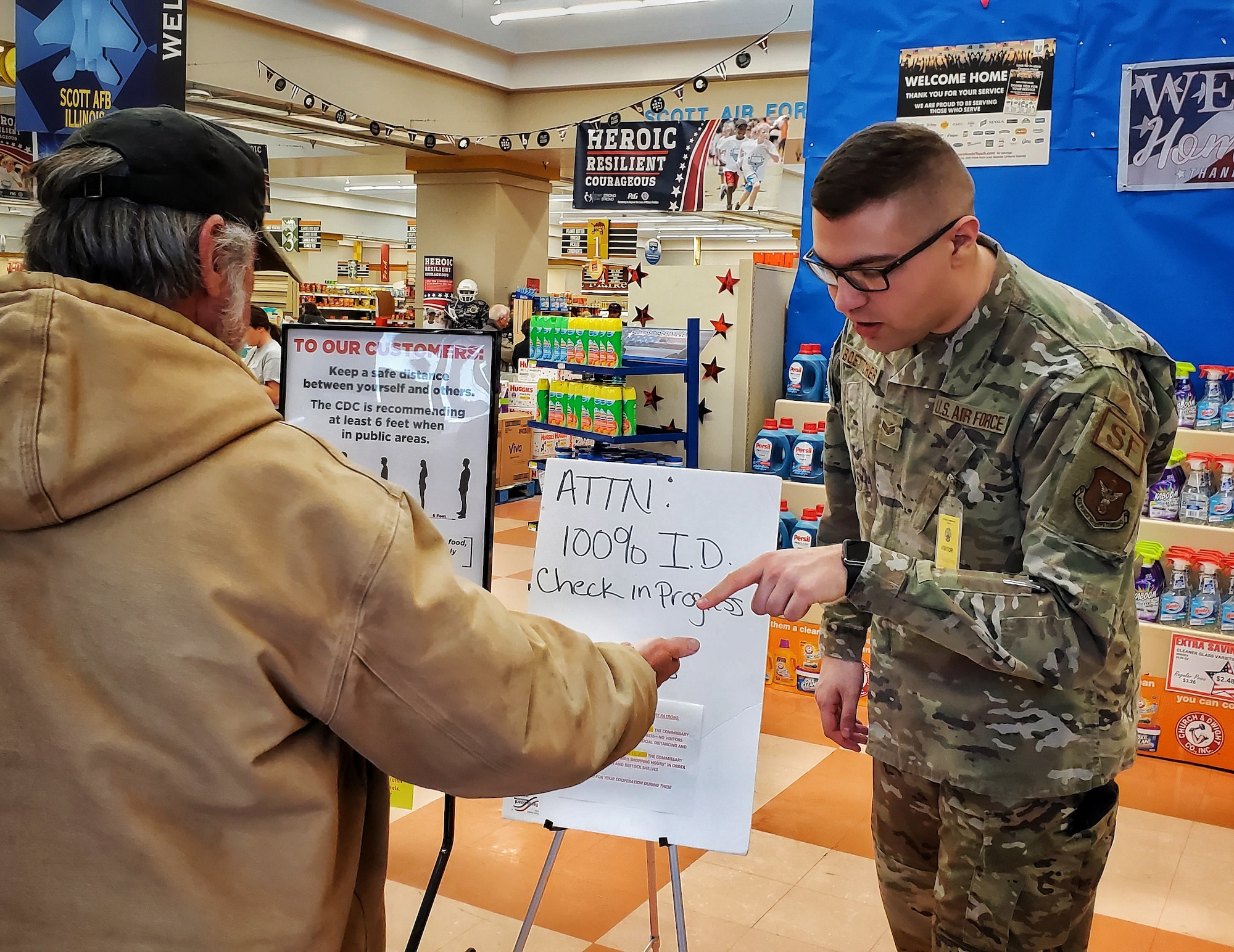 Senior Airman Austen Boettcher, from the 932nd Security Forces Squadron, volunteers to check IDs at the Scott Air Force Base commissary March 20, 2020. (U.S. Air Force photo by Christopher Parr)
