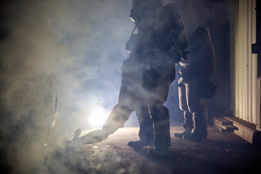 U.S. Marine Corps Pfc. Joshua Torres, center, a chemical, biological, radiological, nuclear Defense specialist with Headquarters Battalion, 2nd Marine Division, recovers a simulated causality during Dismount Recon Sets Kit and Outfits training at the Guardian Center in Perry, Ga., Sept. 18, 2018. DRSKO training enhanced CBRN’s capabilities by providing realistic scenarios to test their minds and techniques. (U.S. Marine Corps photo by Cpl. Melanye Martinez)