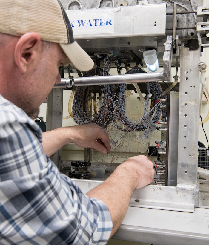 Brian Anderson, an instrumentation specialist, connects wires from a Schmidt-Boelter heat flux gauge to a machine used to calibrate the gauges Jan. 15, 2020, in the Aerothermal Calibration Laboratory at Arnold Air Force Base, Tenn. (U.S. Air Force photo by Jill Pickett)