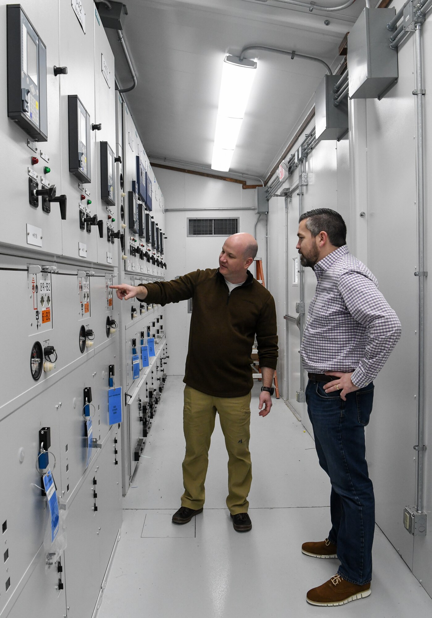 Tyler McCamey, left, an AEDC program manager, observes a gauge on gas-insulated switchgear (GIS) for the Propulsion Wind Tunnel (PWT) Facility, Feb. 14, 2020, at Arnold Air Force Base, Tenn. The switchgear was upgraded to GIS as a Service Life Extension Program effort. Also pictured, Nathan Harrison, former Service Life Extension Program manager for the Capital Improvements Branch. (U.S. Air Force photo by Jill Pickett)