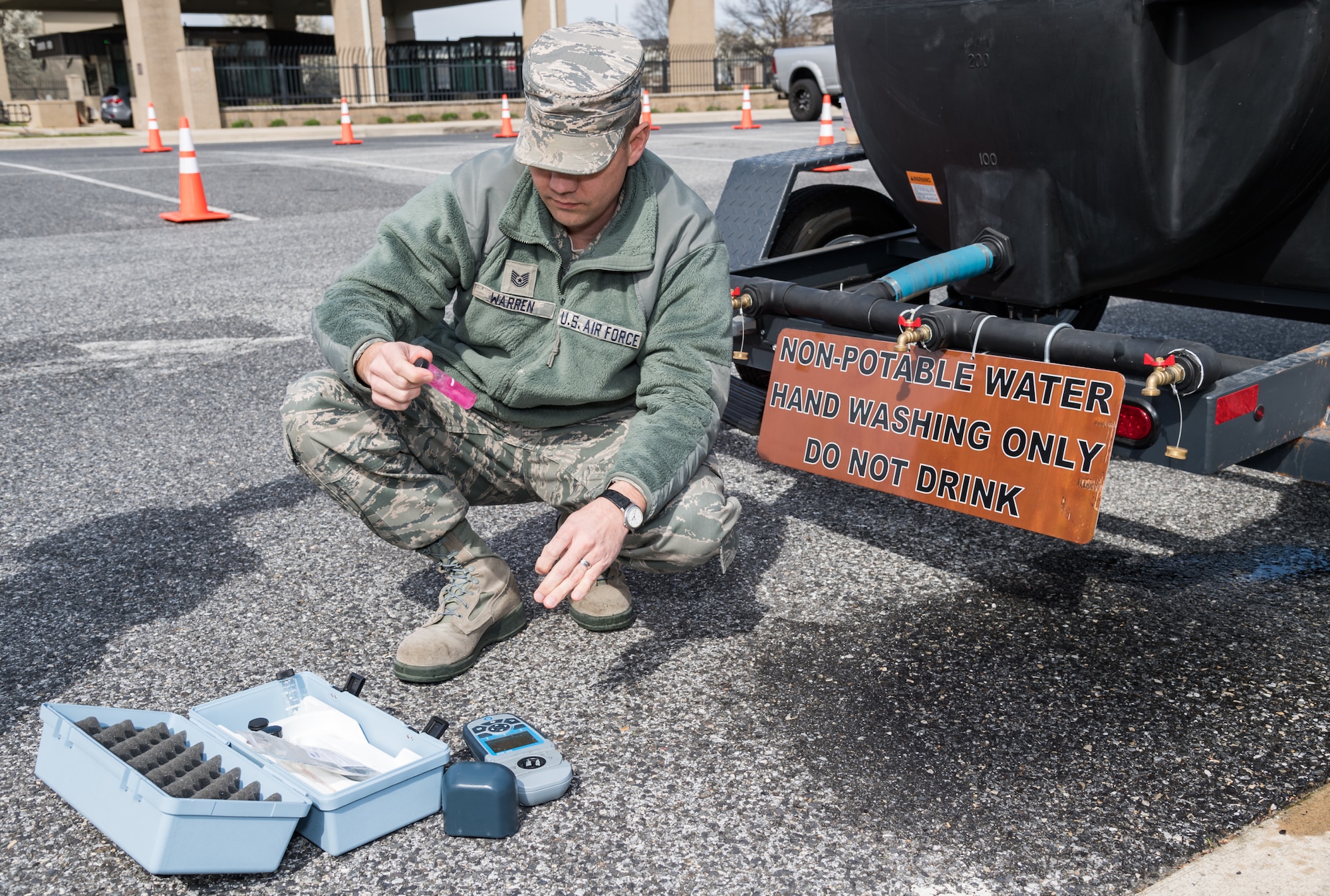 Tech. Sgt. James Warren, 436th Operational Medical Readiness Squadron bioenvironmental engineering flight noncommissioned officer in charge, tests non-potable water for pH and chlorine levels March 18, 2020, at the main gate on Dover Air Force Base, Delaware. Warren used a Hach DR900 Colorimeter to perform the two tests on the water used by 436th Operational Medical Readiness Squadron personnel to wash their hands. After applying hand sanitizer during the screening of medical clinic patrons, 436th OMRS personnel were required to wash their hands after the fifth screening before reapplying more hand sanitizer. (U.S. Air Force photo by Roland Balik)