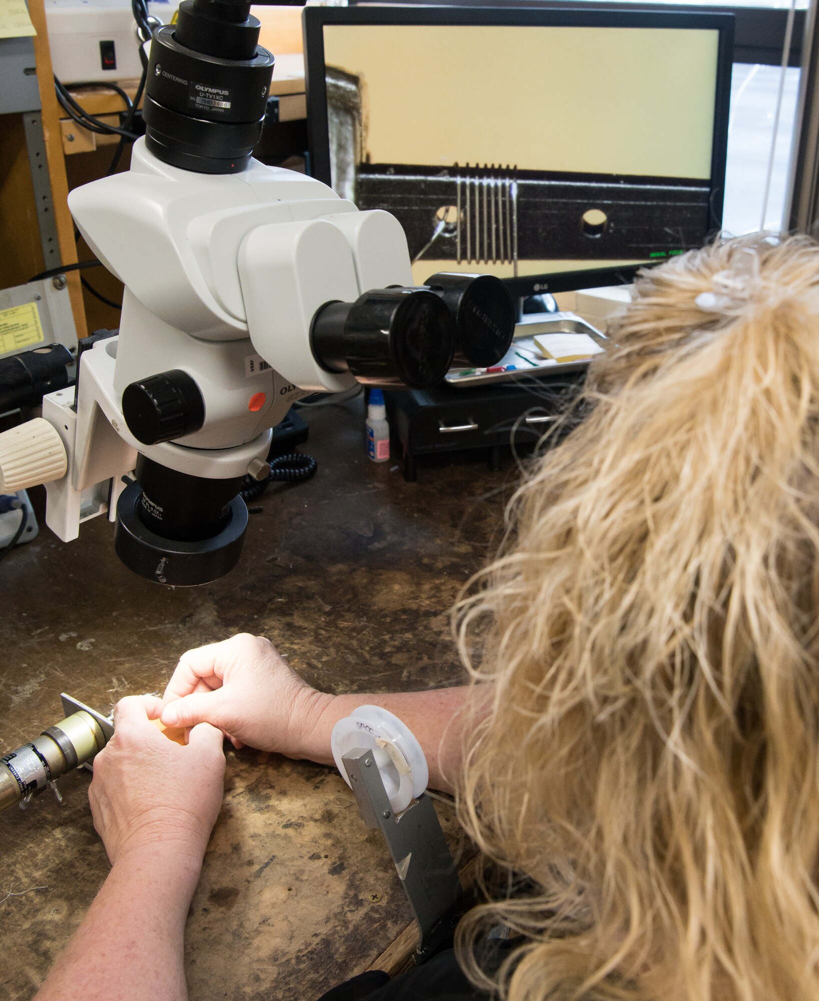 Annette Painter, an instrument technician specialist and AEDC Fellow, watches the image from a microscope projected on a screen as she wraps .002 in. wire around a wafer while demonstrating the making of a Schmidt-Boelter heat flux gauge Jan. 15, 2020, in the Arnold Engineering Development Complex Test Technology, Analysis and Evaluation Branch's Aerothermal Measurements Lab at Arnold Air Force Base, Tenn. (U.S. Air Force photo by Jill Pickett)