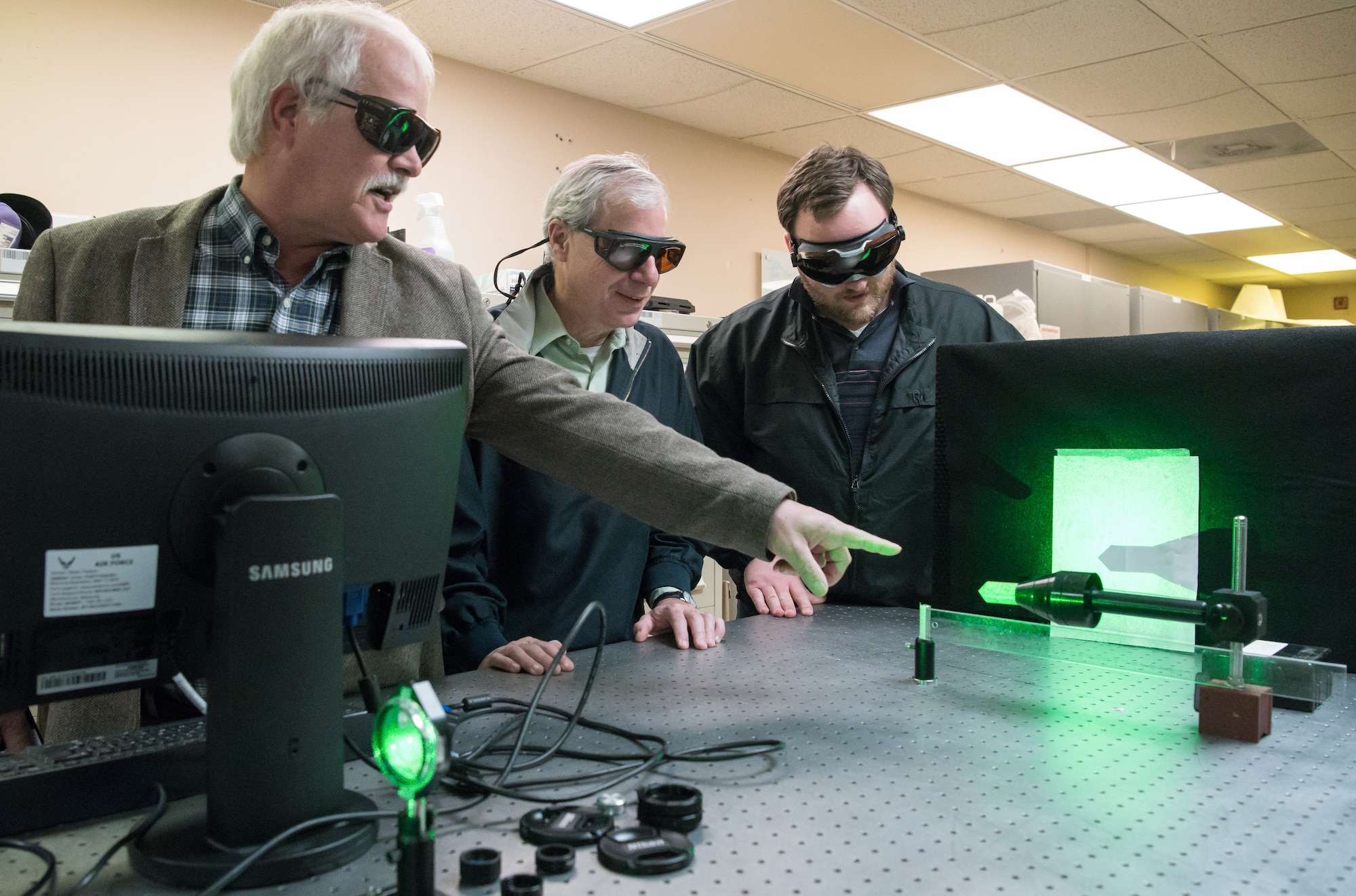 Dr. David Plemmons, left, a senior scientist with the Arnold Engineering Development Complex (AEDC), speaks about the use of a continuous wave laser Jan. 13, 2020, in the Test Technology, Analysis and Evaluation Branch’s Laser Laboratory at Arnold Air Force Base, Tenn. The Branch develops measurement and diagnostic techniques utilizing the lasers in the lab that can then be fielded in AEDC test cells.  Also pictured are Dr. Joe Wehrmeyer, center, technical advisor to the Technology Section of the Branch, and Joe Braker, an optical engineer. (U.S. Air Force photo by Jill Pickett)