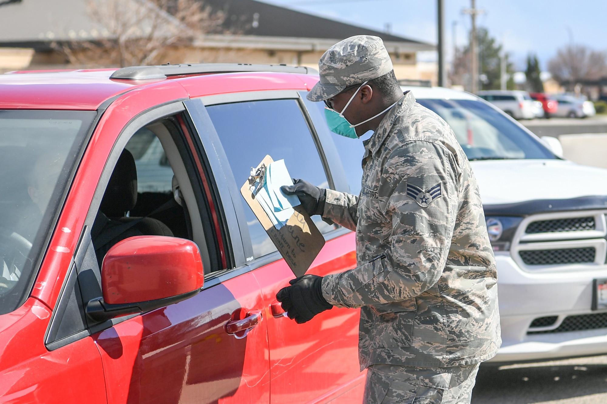 Senior Airman Elijah Thompkins, 75th Medical Group, consults with a beneficiary March 23, 2020, at Hill Air Force Base, Utah. The 75th Medical Group Satellite Pharmacy is providing curbside service until further notice in front of the Base Exchange shopping center in support of social distancing recommendations and to increase efforts to mitigate further spread of the novel coronavirus.(U.S. Air Force photo by Cynthia Griggs)