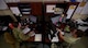 Two Airmen sit at their desk.