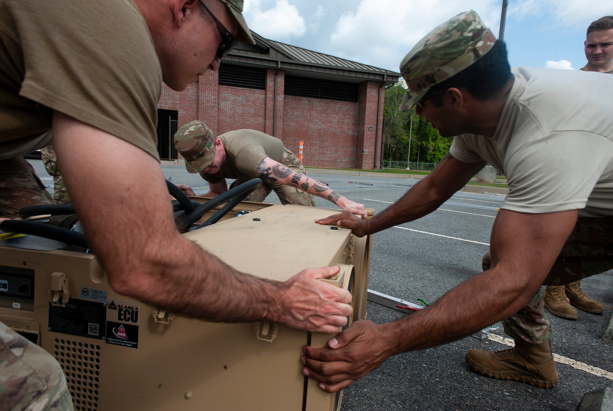 A photo of Airmen moving an air conditioning unit.
