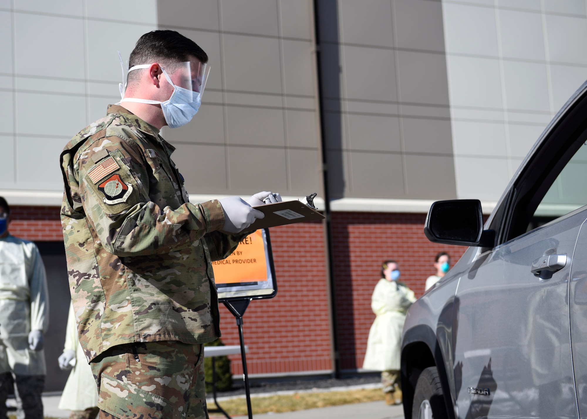 92nd Medical Group Airmen screen a patient prior to their entrance into the 92nd MDG on Fairchild Air Force Base, Washington, March 17, 2020. All visitors to the 92nd MDG must go through this screening process to prevent the spread of COVID-19. (U.S. Air Force photo by Senior Airman Lawrence Sena)