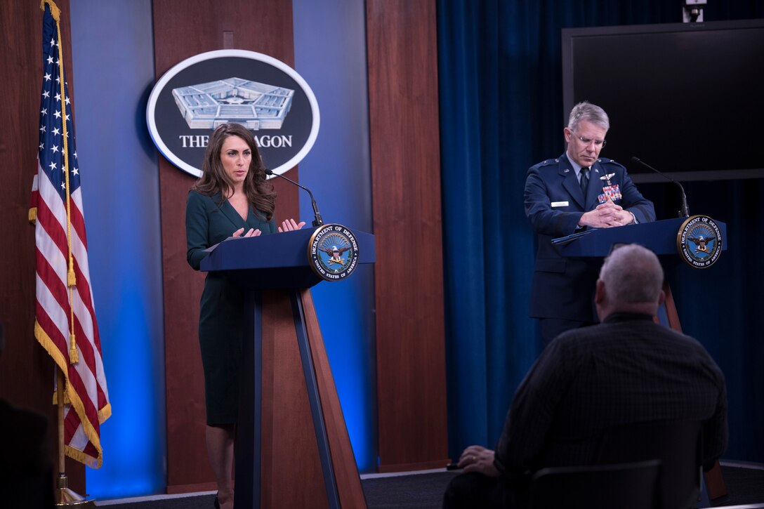 A man and woman stand behind two podiums.