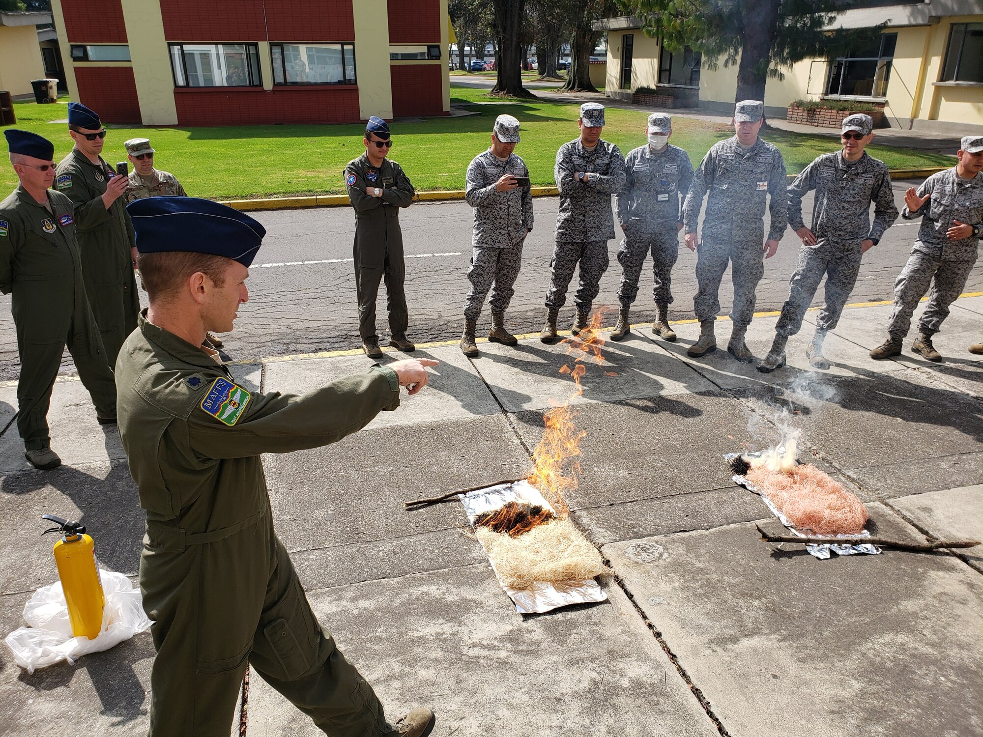 U.S. Air Force Lt. Col. Richard Pantusa, 731st Airlift Squadron Modular Airborne Fire Fighting Systems instructor pilot from Peterson Air Force Base, Colorado, demonstrates the effectiveness of fire retardant in combating forest fires to members from the Fuerza Aerea Colombiana. Employing an aerial firefighting capability will help the FAC in combatting wild fires, both internally and internationally. The specialized training, provided by the U.S. Air Force Reserve Command personnel, was a stepping stone to future work with the FAC on further enhancing this capability. (Courtesy Photo)