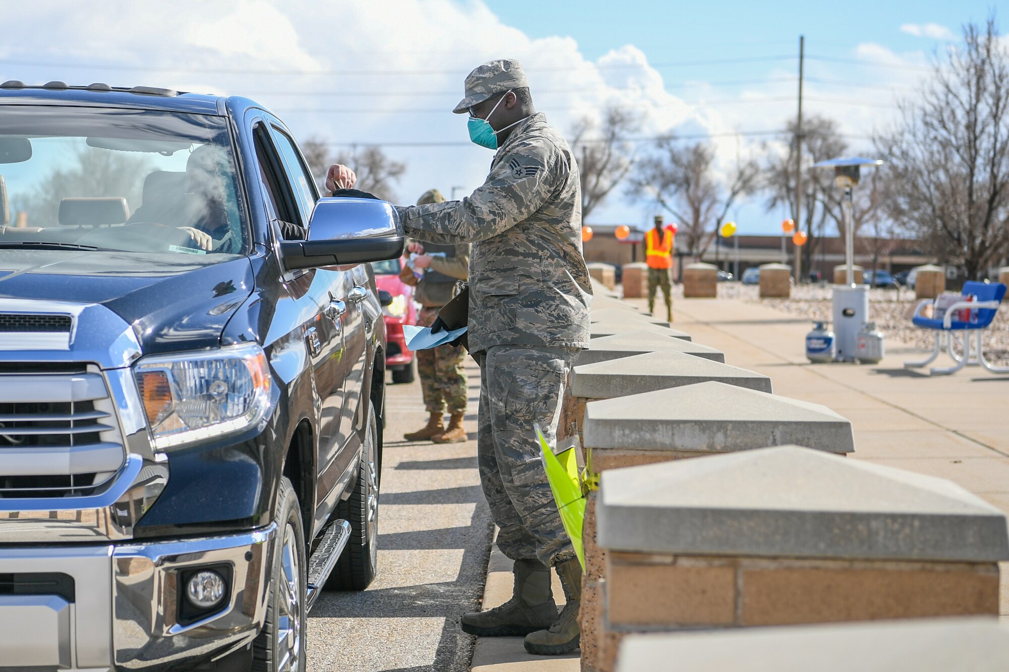 U.S. Air Force Senior Airman Elijah Thompkins, 75th Medical Group, hands a prescription over to a beneficiary at Hill Air Force Base, Utah, March 23, 2020. The 75th Medical Group Satellite Pharmacy is providing curbside service until further notice in front of the Base Exchange shopping center in support of social distancing recommendations and to increase efforts to mitigate further spread of the novel coronavirus. (U.S. Air Force photo by Cynthia Griggs)