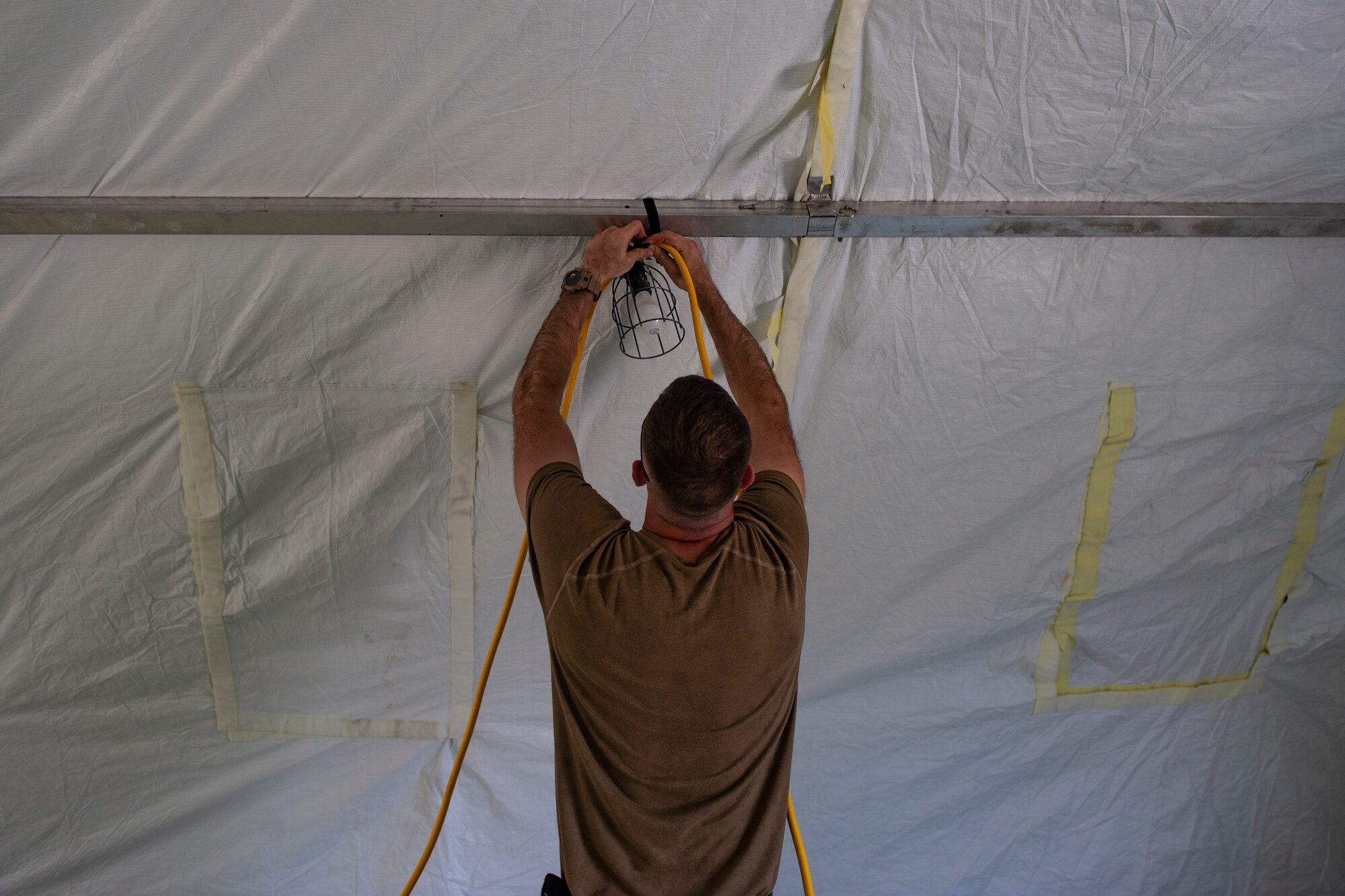 A photo of an Airman moving a light bulb.