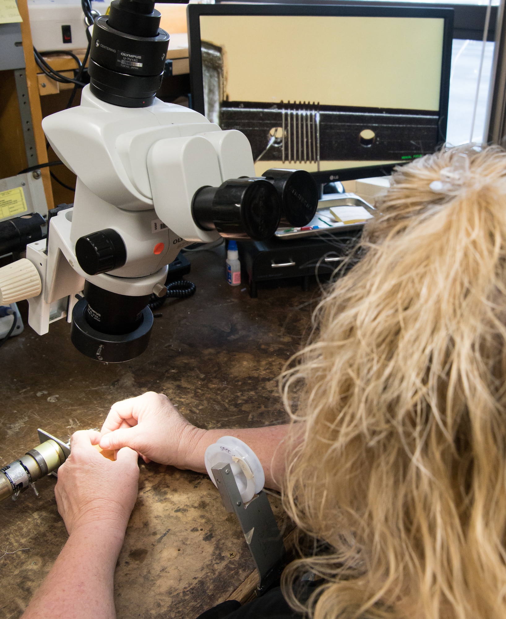 Annette Painter, an instrument technician specialist and AEDC Fellow, watches the image from a microscope projected on a screen as she wraps .002 in. wire around a wafer while demonstrating the making of a Schmidt-Boelter heat flux gauge Jan. 15, 2020, in the Arnold Engineering Development Complex Test Technology, Analysis and Evaluation Branch's Aerothermal Measurements Lab at Arnold Air Force Base, Tenn. (U.S. Air Force photo by Jill Pickett)