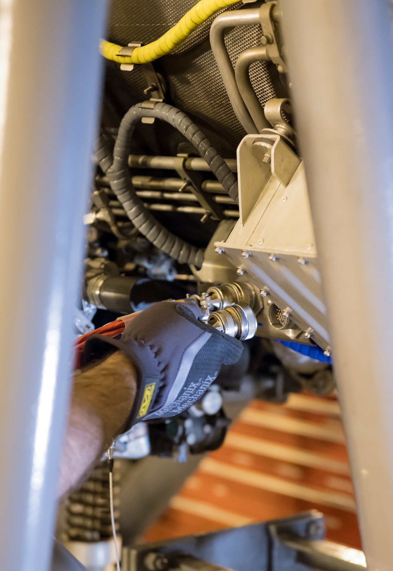 Evan Milligan, a journeyman wireman, connects cables to a F404 engine Jan. 10, 2020, in a sea level test cell at Arnold Air Force Base, Tenn. The engine is being prepared for use as a testbed by the Arnold Engineering Development Complex Technology, Analysis and Evaluation Branch. (U.S. Air Force photo by Jill Pickett)