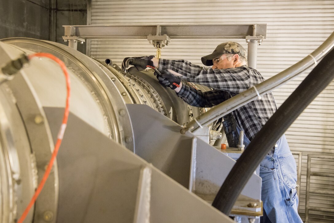 Stan Freeze, an outside machinist, removes a plug from a borescope inspection port on an F404 engine Jan. 10, 2020, in a sea level test cell at Arnold Air Force Base, Tenn.  The engine is being prepared for use as a testbed by the Arnold Engineering Development Complex Technology, Analysis and Evaluation Branch. (U.S. Air Force photo by Jill Pickett)