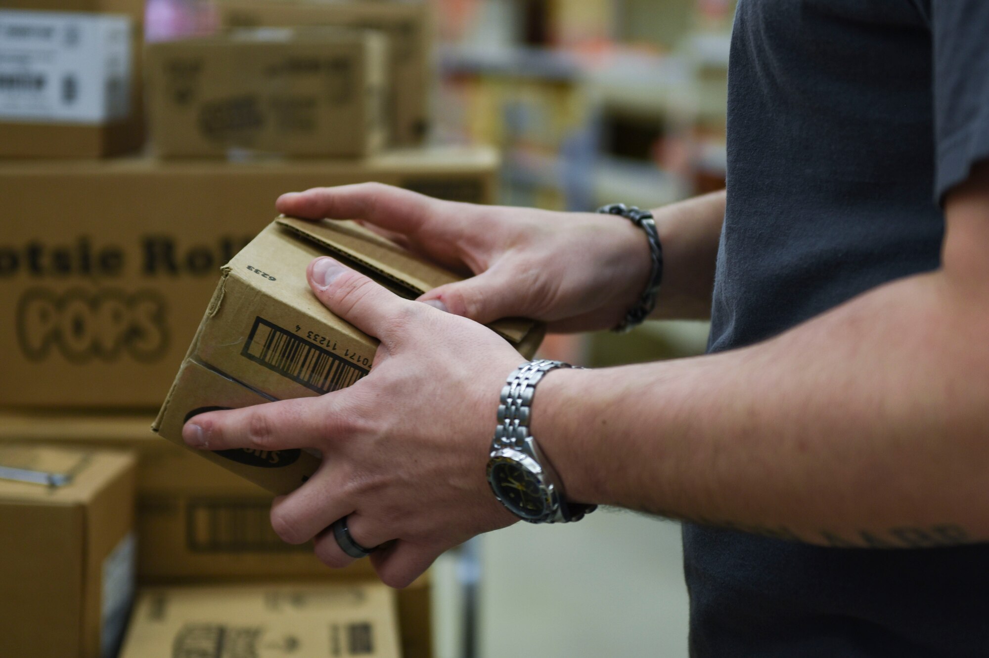 U.S. Air Force Senior Airman Eric Peffer, 52nd Security Forces Squadron armory operations manager, un-boxes groceries in the Commissary at Spangdahlem Air Base, Germany, March 23, 2020. Peffer volunteered to stock shelves, and said in times like these we need to work together as a team and push through. (U.S. Air Force photo by Senior Airman Melody W. Howley)