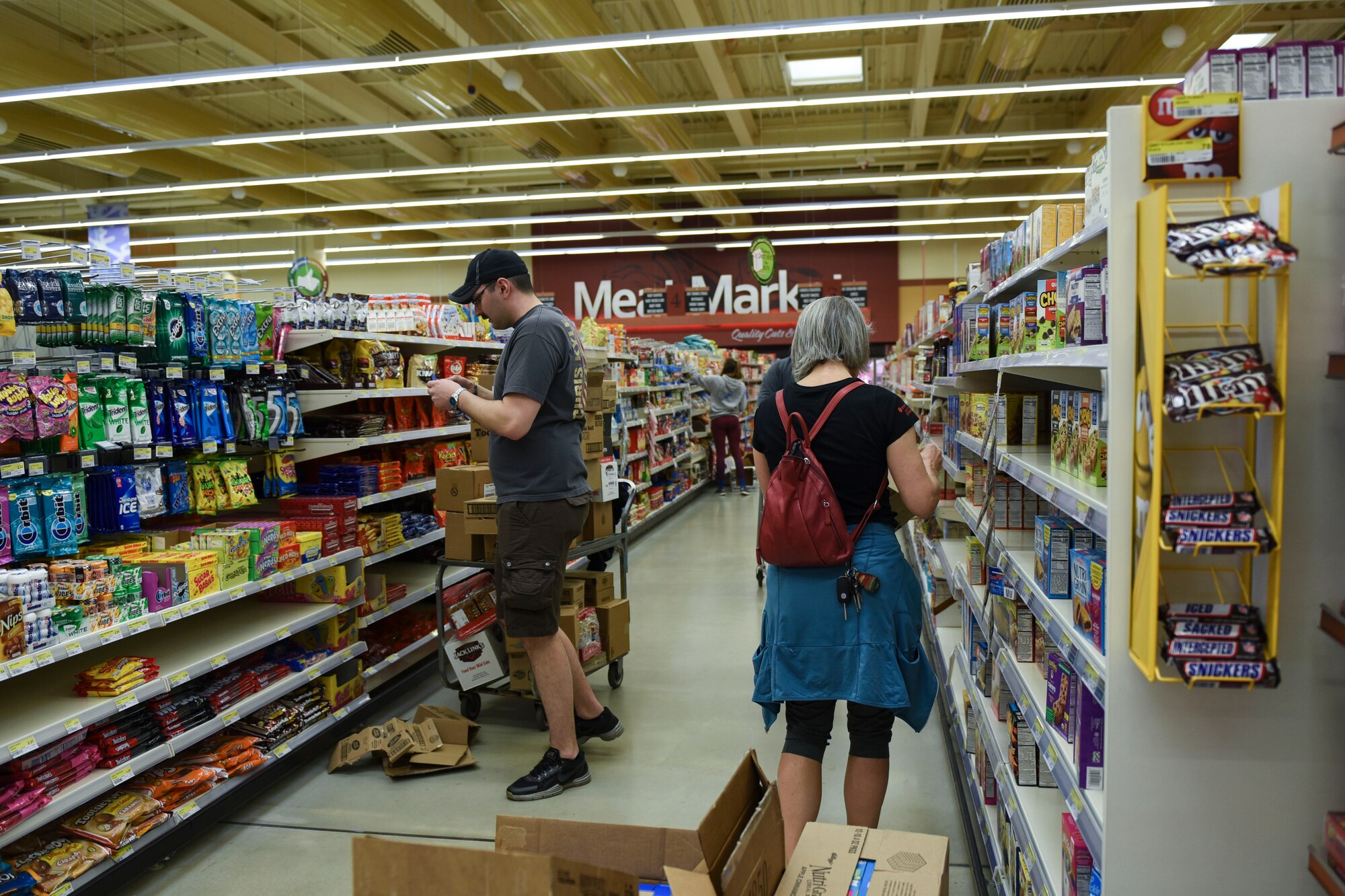 Airmen and families volunteer in the Commissary at Spangdahlem Air Base, Germany, March 23, 2020. Volunteers throughout the base community offered to box and stock shelves because of the current high demand of products. (U.S. Air Force photo by Senior Airman Melody W. Howley)