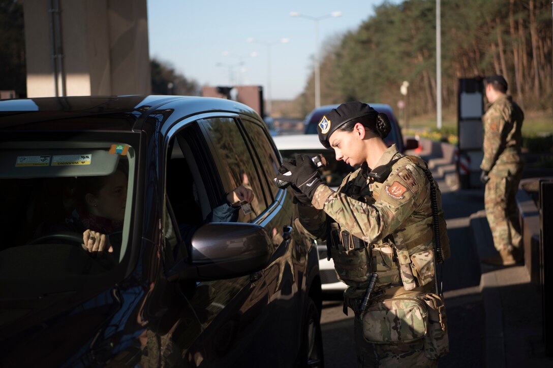 U.S. Air Force Staff Sgt. Robyn Thayer, 86th Security Forces Squadron patrolman, verifies an individuals ID before granting them access to Ramstein Air Base, Germany, March 24, 2020.