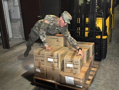 A Soldier from the 563rd Medical Logistics Company unloads a delivery of medical supplies to support the medical materiel response to COVID-19.