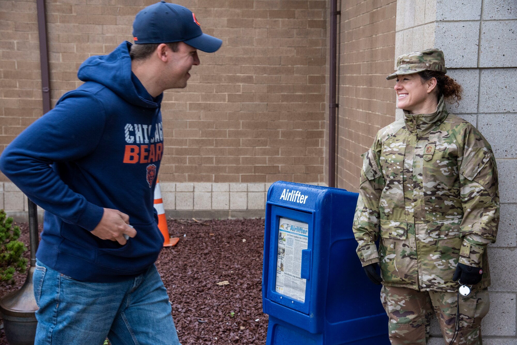 Chief Master Sgt. Shae Gee, 436th Airlift Wing command chief, greets a customer after checking an ID at the Commissary March 25, 2020, at Dover Air Force Base, Del. The Chiefs Group and First Sergeants volunteered at the Commissary checking IDs, assisting with social distancing measures, and stocking shelves to help mitigate the spread of COVID-19, reduce confusion and ensure Airmen and their families still had access to essential items. (U.S. Air Force Photo by Airman 1st Class Jonathan Harding)