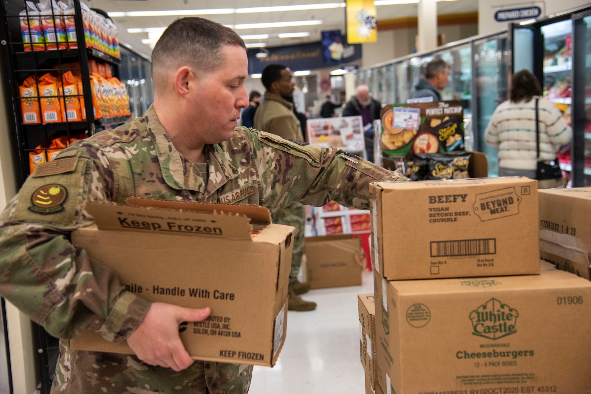 Senior Master Sgt. Alex Asencio Soto, 373rd Training Squadron superintendent, stocks frozen goods at the Commissary March 25, 2020 at Dover Air Force Base, Delaware. The Chiefs Group and First Sergeants volunteered at the Commissary checking IDs, assisting with social distancing measures, and stocking shelves to help mitigate the spread of COVID-19, reduce confusion and ensure Airmen and their families still had access to essential items. (U.S. Air Force Photo by Airman 1st Class Jonathan Harding)