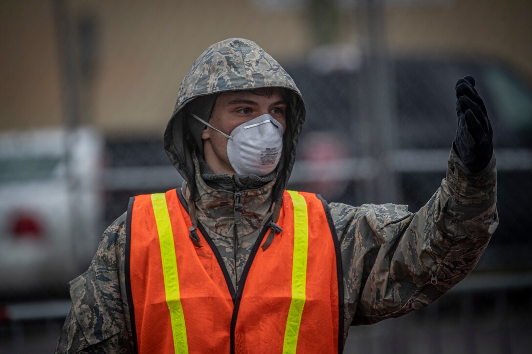 A New Jersey Air Guard Airman from the 108th Wing provides traffic control at a COVID-19 Community-Based Testing Site at the PNC Bank Arts Center in Holmdel, N.J., March 23, 2020.  The testing site, established in partnership with the Federal Emergency Management Agency, is staffed by the New Jersey Department of Health, the New Jersey State Police, and the New Jersey National Guard. (U.S. Air National Guard photo by Master Sgt. Matt Hecht)