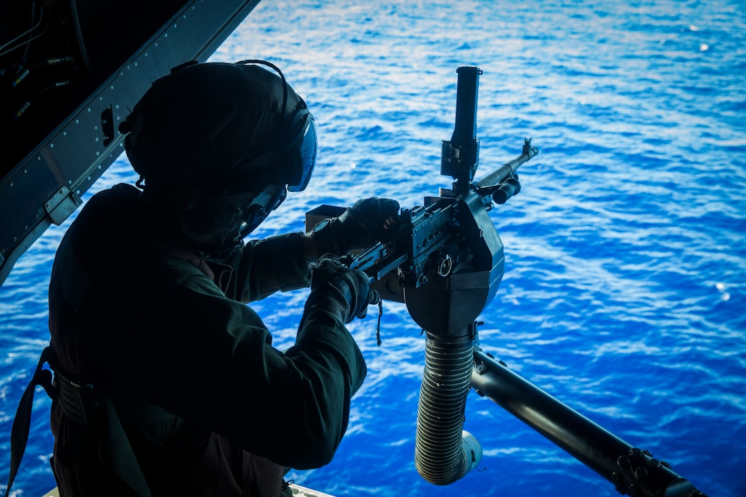 A U.S. Marine takes apart an M240B machine gun during a tail gunnery live fire exercise aboard amphibious assault ship USS America (LHA 6), March 22.