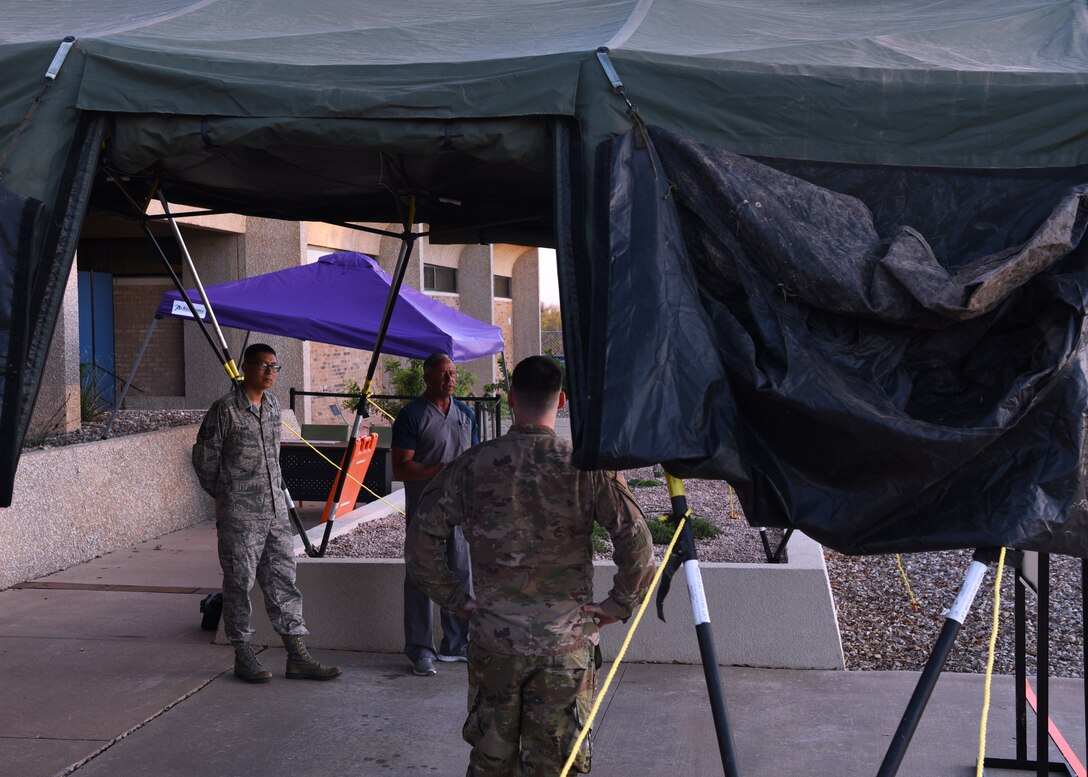 U.S. Air Force members of the 17th Medical Group strategize their pre-screening process before patients arrive to the Ross Clinic on Goodfellow Air Force Base, Texas, March 25, 2020.  Medical resources have been restricted at the Ross Clinic to active duty members and patients seeing providers, in response to the COVID-19 pandemic.  (U.S. Air Force photo by Airman 1st Class Abbey Rieves)