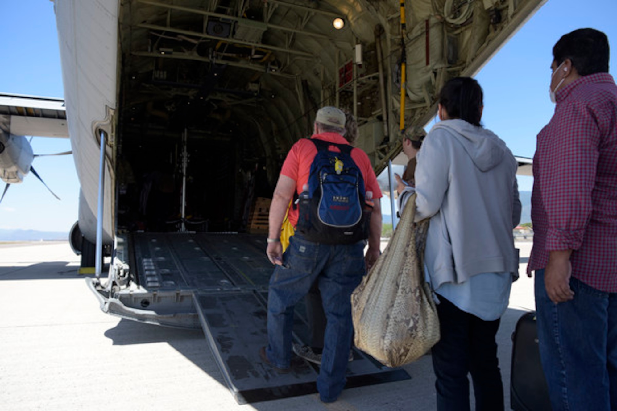 U.S. citizens board a U.S. Air Force C-130J Super Hercules at Soto Cano Air Base, Honduras, March 25, 2020. The aircraft was used to transport 78 evacuees from Honduras to Naval Air Station Norfolk, Va. The mission is part of an ongoing interagency effort led by the U.S. State Department to assist American citizens unable to return home from countries around the world during the COVID-19 pandemic. (U.S. Air Force photo by Tech. Sgt. Daniel Owen)