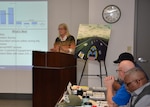 Barbara Roberts stands and delivers remarks to seated people.