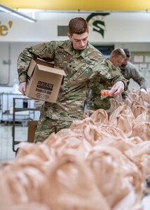 Spc. Aiden Mitchell, a member of C Battery, 1st Battalion, 201st Field Artillery Regiment of the West Virginia National Guard assists volunteers with the Greater Greenbrier Long Term Recovery Committee in preparing meals for more than 3,600 school-age students throughout Greenbrier County, West Virginia, during the COVID-19 pandemic outbreak, March 25, 2020, in Lewisburg, West Virginia. WVNG Soldiers supported more than 30 volunteers in packaging and delivering the meals to needy children around the county and will continue to do so for the duration of the outbreak. (U.S. Army National Guard photo by Edwin L. Wriston)