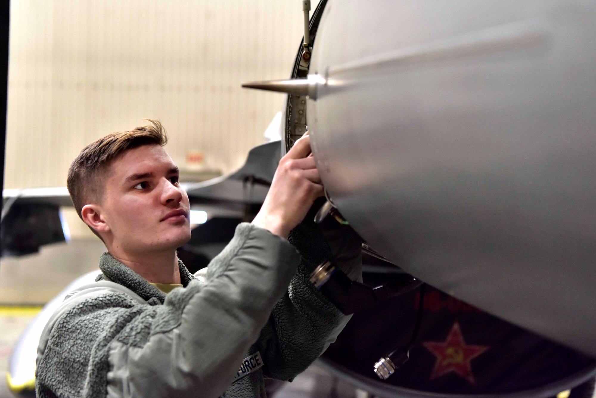 Airman 1st Class Cody Cornett, a 354th Aircraft Maintenance Squadron avionics specialist, works on an F-16 Fighting Falcon on Eielson Air Force Base, Alaska, March 24, 2020. In accordance with Center for Disease Control recommendations, Eielson Airmen are mandated to practice health safety measures including social distancing, consistent hand washing and sanitizing work areas at the start and end of their shift. (U.S. Air Force photo by Senior Airman Beaux Hebert)