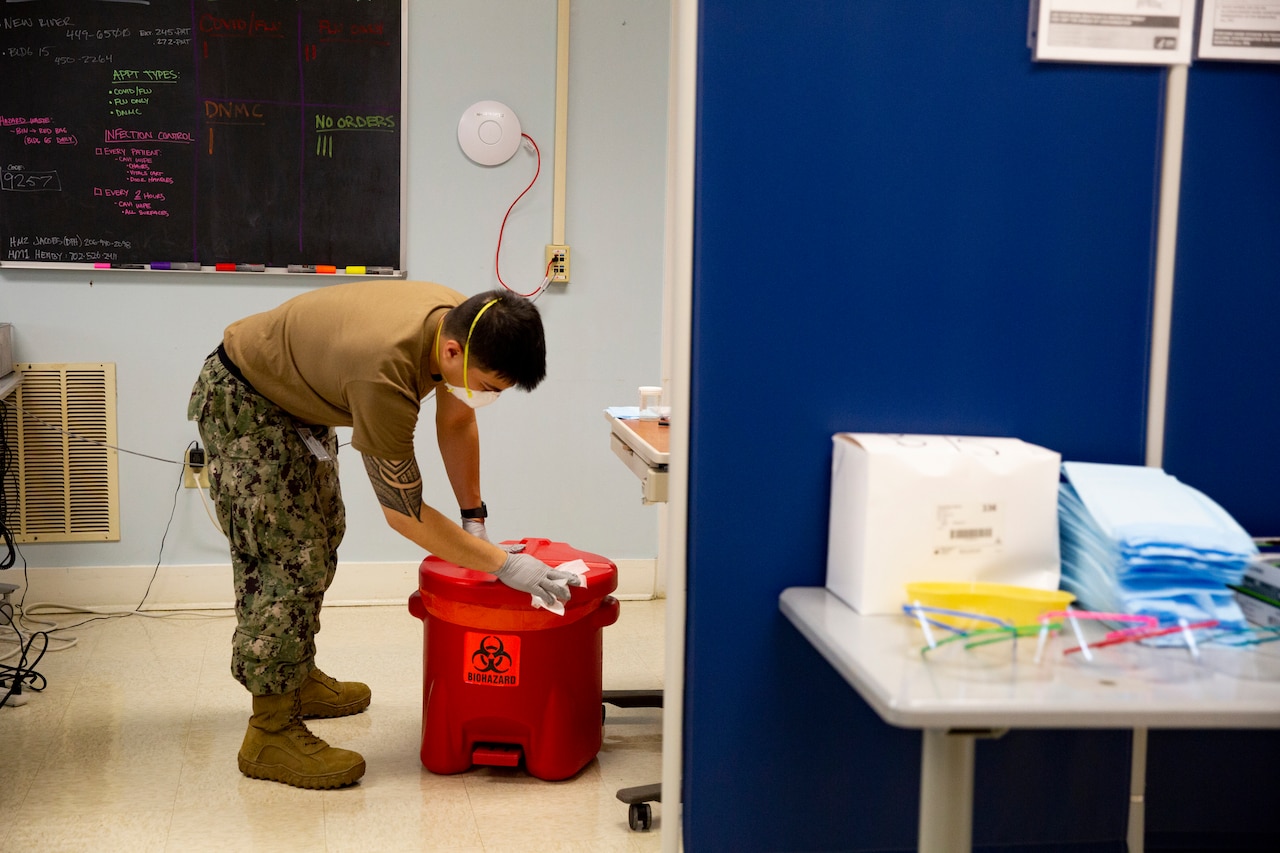 A person scrubs to disinfect equipment.