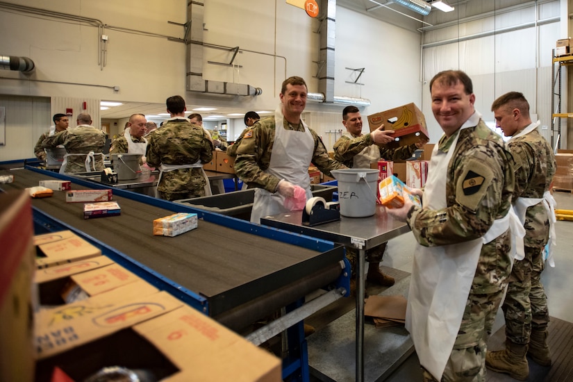 Soldiers sort food at food bank.