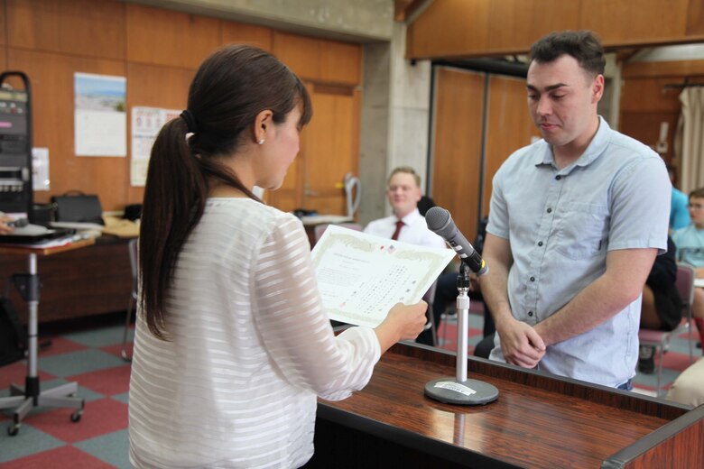 LCpl Jolden K. Mitchell receives a certificate of appreciation from the Nago City Board of Education for the "English Camp for Elementary School Children" March 25 at the Nago Central Community Center.