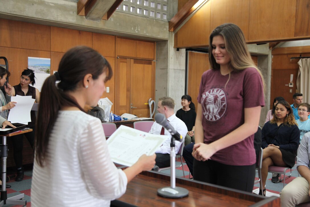 Aimee Miles receives a certificate of appreciation from the Nago City Board of Education for the "English Camp for Elementary School Children" March 25 at the Nago Central Community Center.