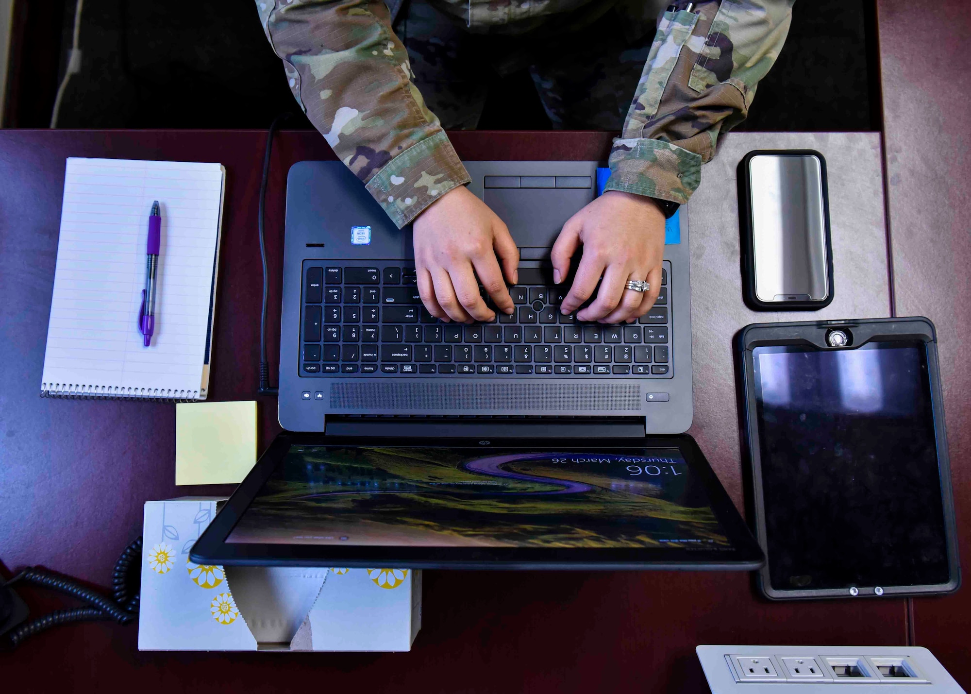 A U.S. Air Force member teleworks from home to practice social distancing. Staying home if sick, and self-quarantining if exposed to those with COVID-19 symptoms (coughing, fever, shortness of breath), and teleworking when possible has been highly encouraged in both the civilian and military sectors. (U.S. Air Force photo by Airman 1st Class Kiaundra Miller)